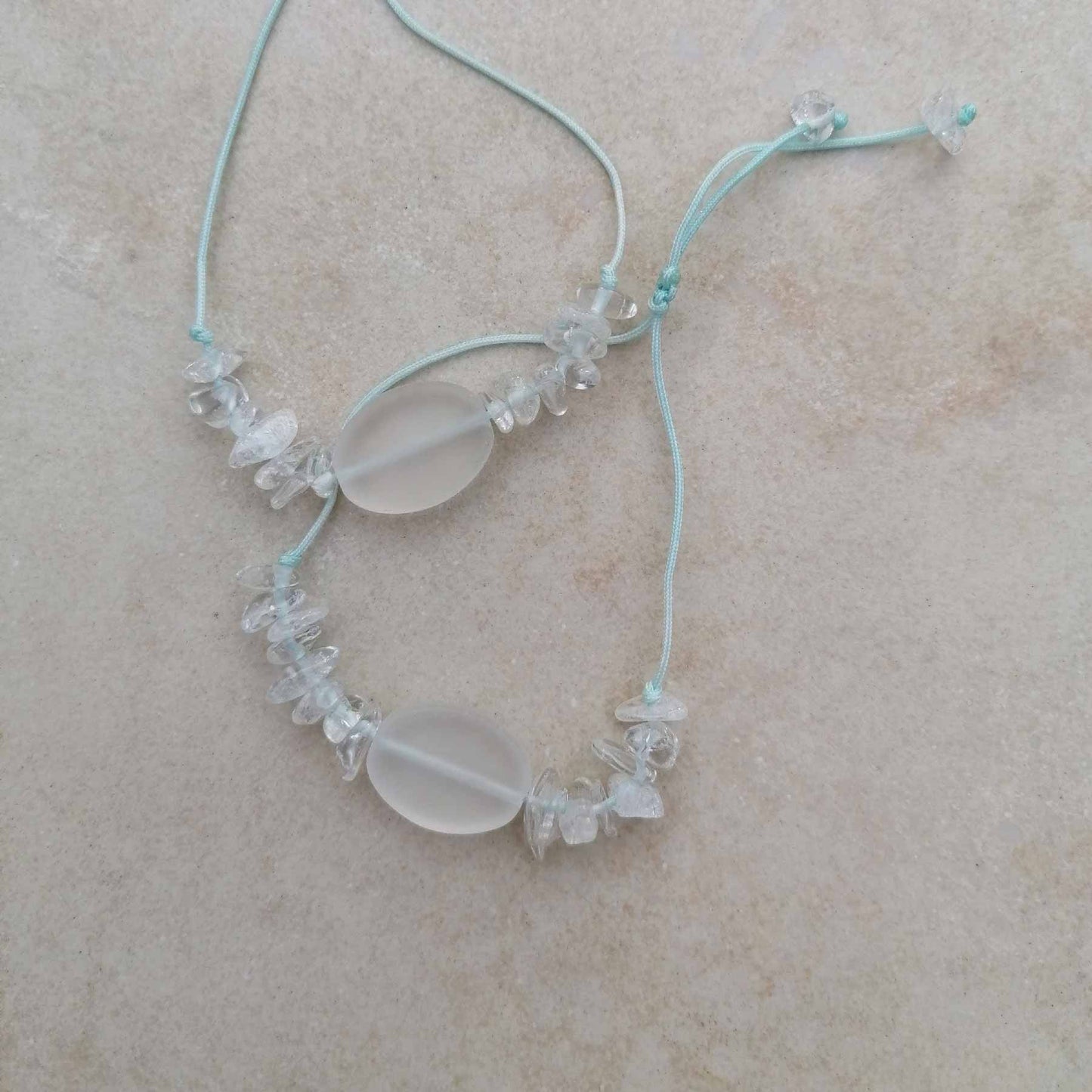Zwei Bergkristall Armbänder mit mattem Stein und Chips auf aqua Kordel