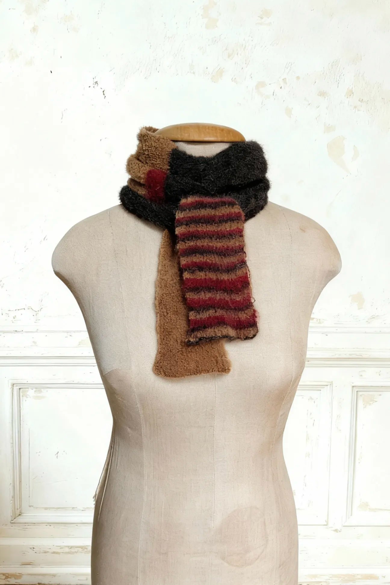 Eng um den Hals der Puppe gewickelter Schal. Ende des extra langen Skinny Schals, zeigt die Farbübergänge von Kamelbraun zu den roten Mohair-Akzenten.