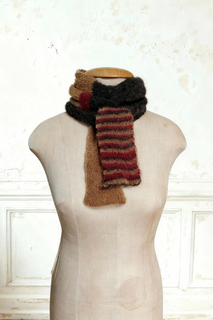 Eng um den Hals der Puppe gewickelter Schal. Ende des extra langen Skinny Schals, zeigt die Farbübergänge von Kamelbraun zu den roten Mohair-Akzenten.