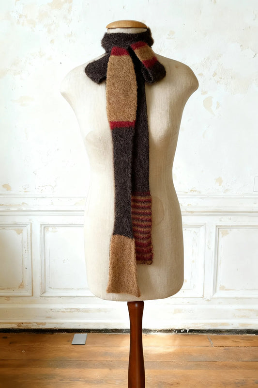 Detailansicht des Skinny Schals, eng am Hals gewickelt und leicht geknotet, zeigt Anthrazitbraun und Bouclé-Kamelbraun und Bordeaux-Rot.